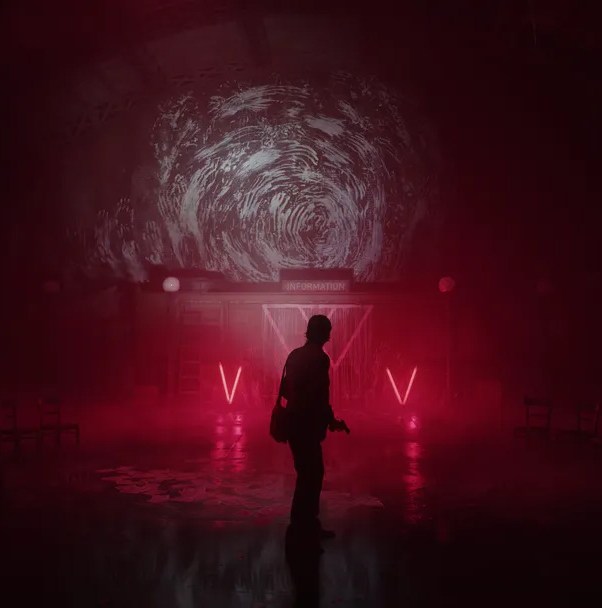 Alan Wake stands in a dimly lit room.