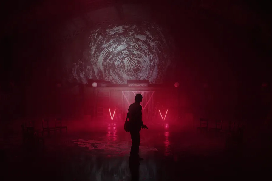Alan Wake stands in a dimly lit room.