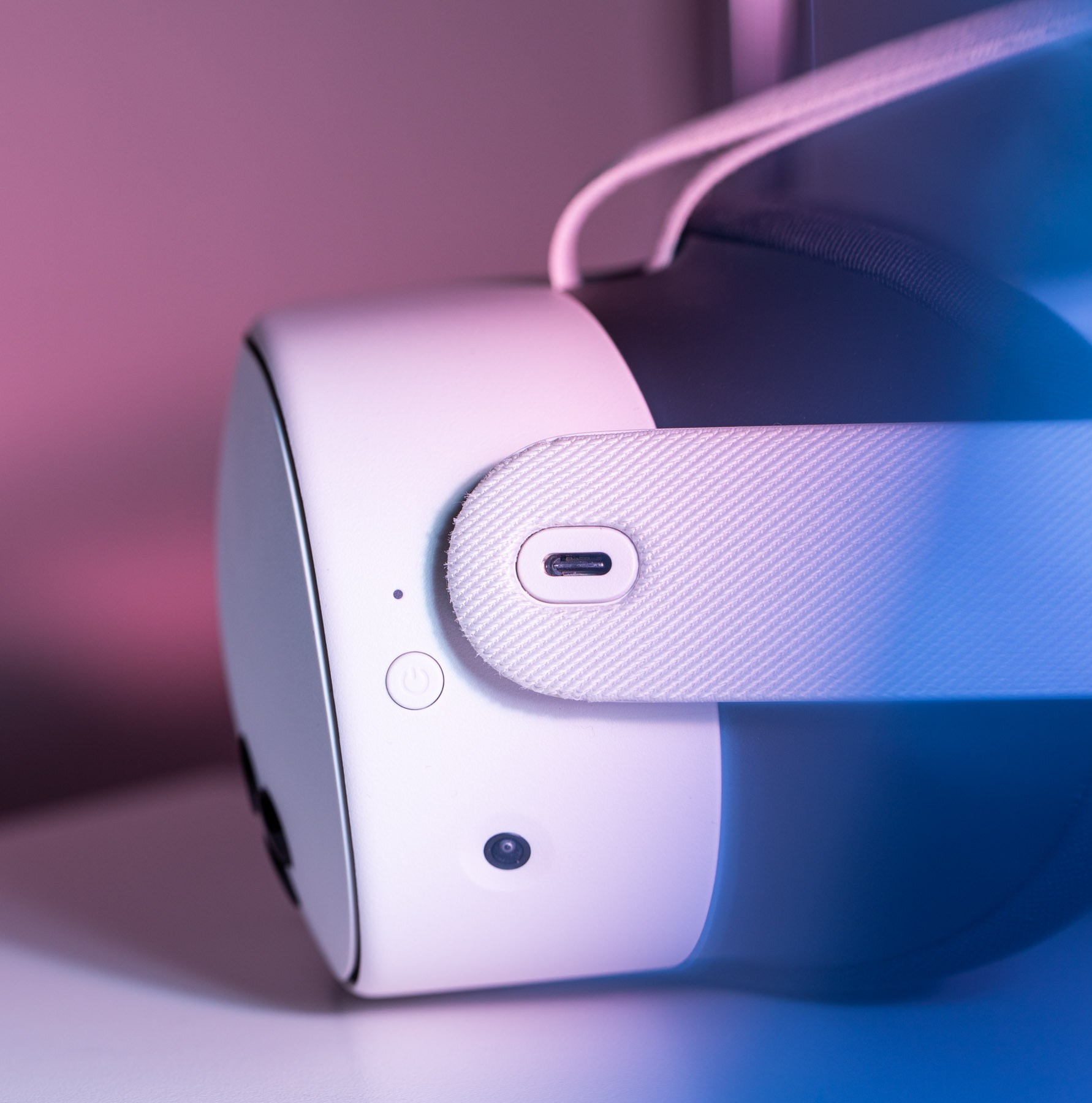 A side view of a white Meta Quest 3S headset. In the center is a a USB-C charging port with a white oval around it.